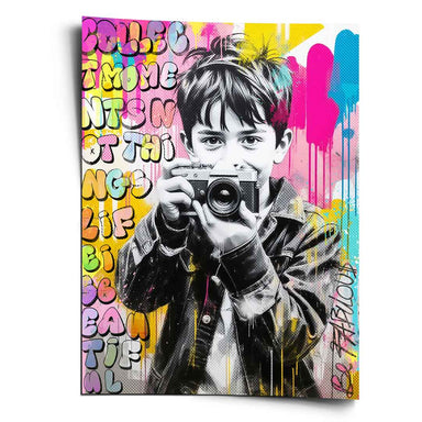 Portrait-format Pop Art wall art print of a smiling boy with a vintage camera in a black-and-white halftone, surrounded by neon yellow, pink, and blue graffiti and motivational text