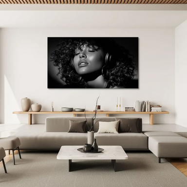 Monochrome photograph of a relaxed woman with curly hair, listening to music with eyes closed.