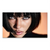 Close-up portrait of a woman with a dark bob and bangs, direct gaze, peachy-orange background, dramatic lighting