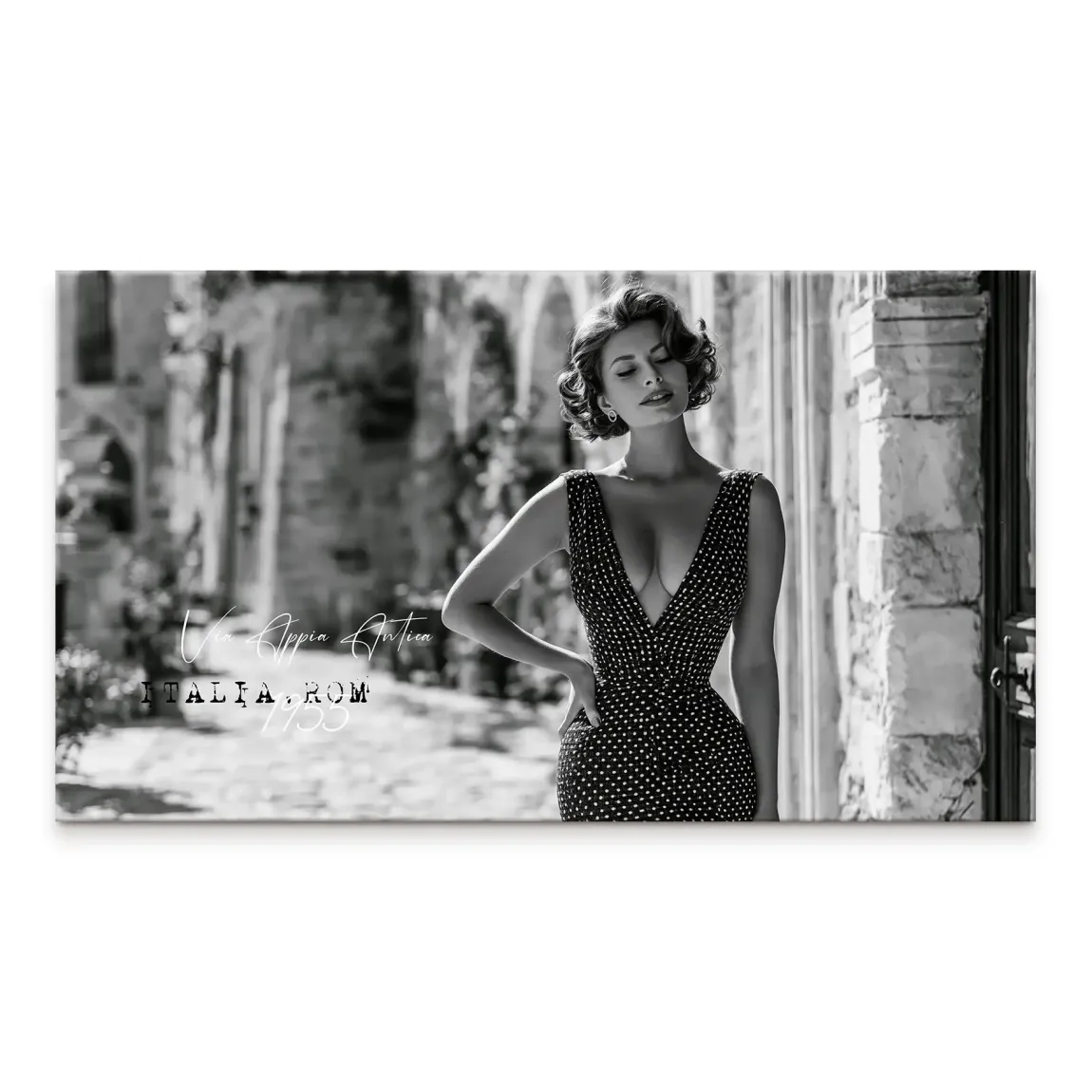 Black and white portrait of a glamorous woman in a polka-dot dress against Roman arches.