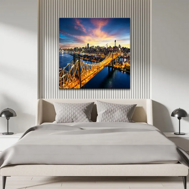 New York City skyline panorama at sunset with warm lights reflected on the water.
