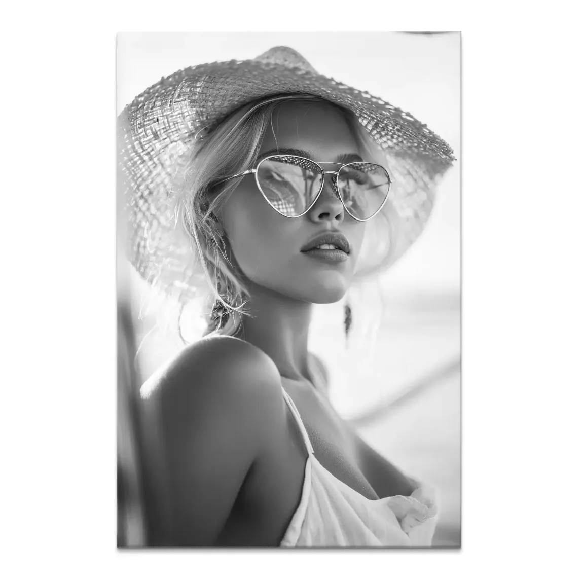 Black-and-white close-up portrait of a chic woman wearing a straw hat and heart-shaped sunglasses