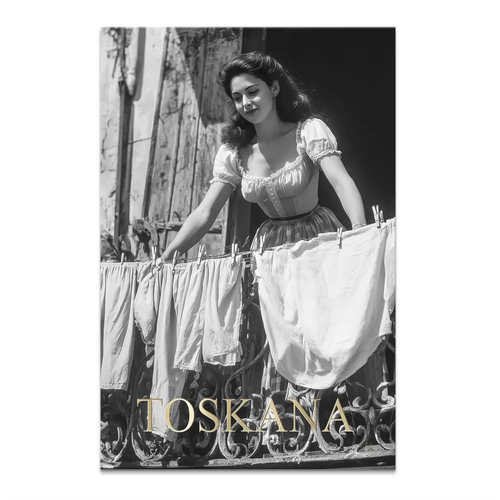 Black-and-white vintage photograph of a woman on a decorative balcony hanging laundry