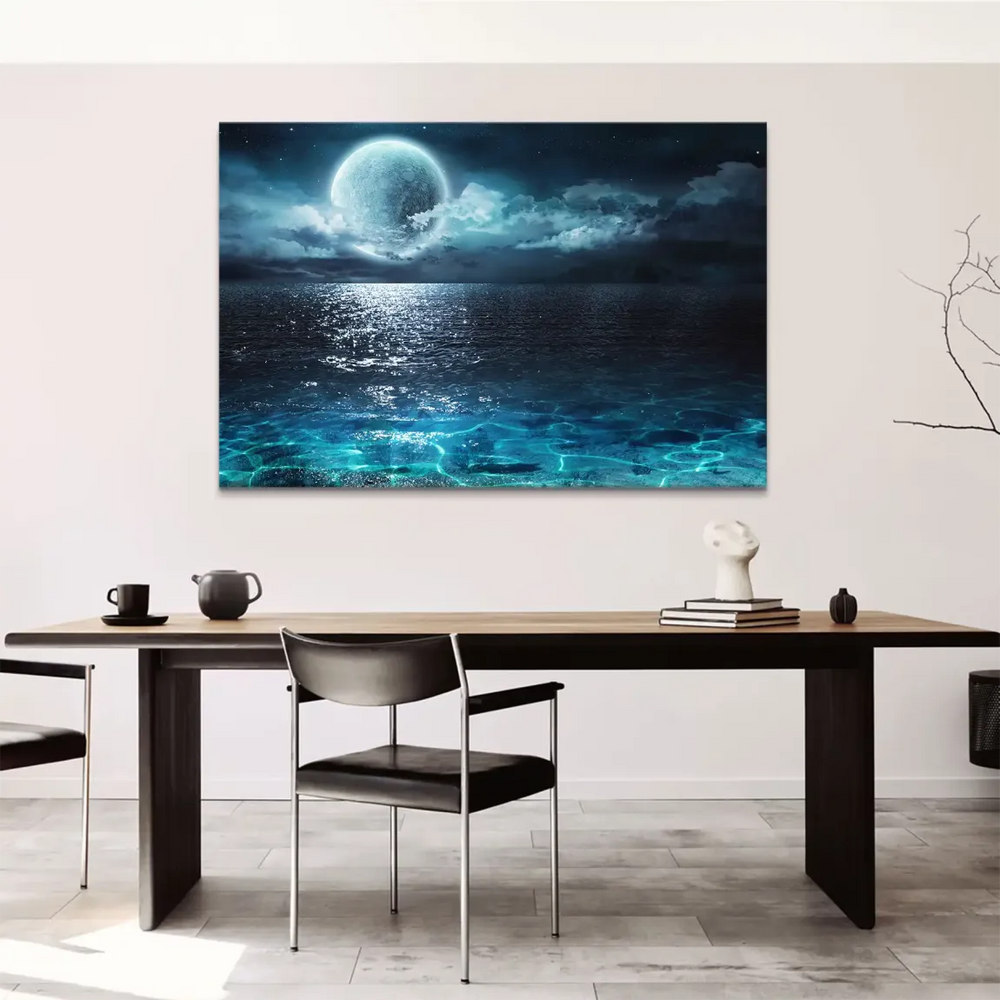 Dramatic night sky over calm sea with silver-white moonlight and textured clouds