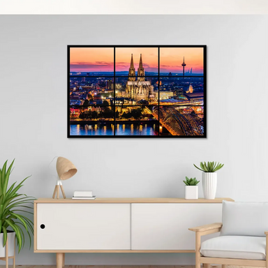 Cologne skyline bathed in orange, pink, and purple twilight over the city