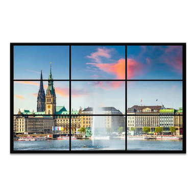 Hamburg cityscape at sunset seen through a nine-pane window featuring Rathaus and St. Peter's Church over Inner Alster Lake