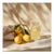 Bright yellow lemons in a rustic linen bag with a glass lemonade jar on a light surface