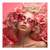 Close-up portrait of a woman with cascading pink flowers, blonde curly hair, and pink-tinted sunglasses on a pink background.