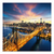 Aerial view of Manhattan at dusk with the Queensboro Bridge over the East River and a glowing skyline.
