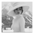 Black-and-white portrait of a stylish woman wearing a wide brim hat and ribbed turtleneck against a snowy mountain backdrop