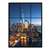 New York City skyline at dusk viewed through a black-framed window with One World Trade Center illuminated against a deep blue sky.