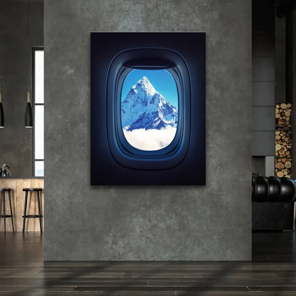 Snow-capped Everest peak framed by airplane window in flight