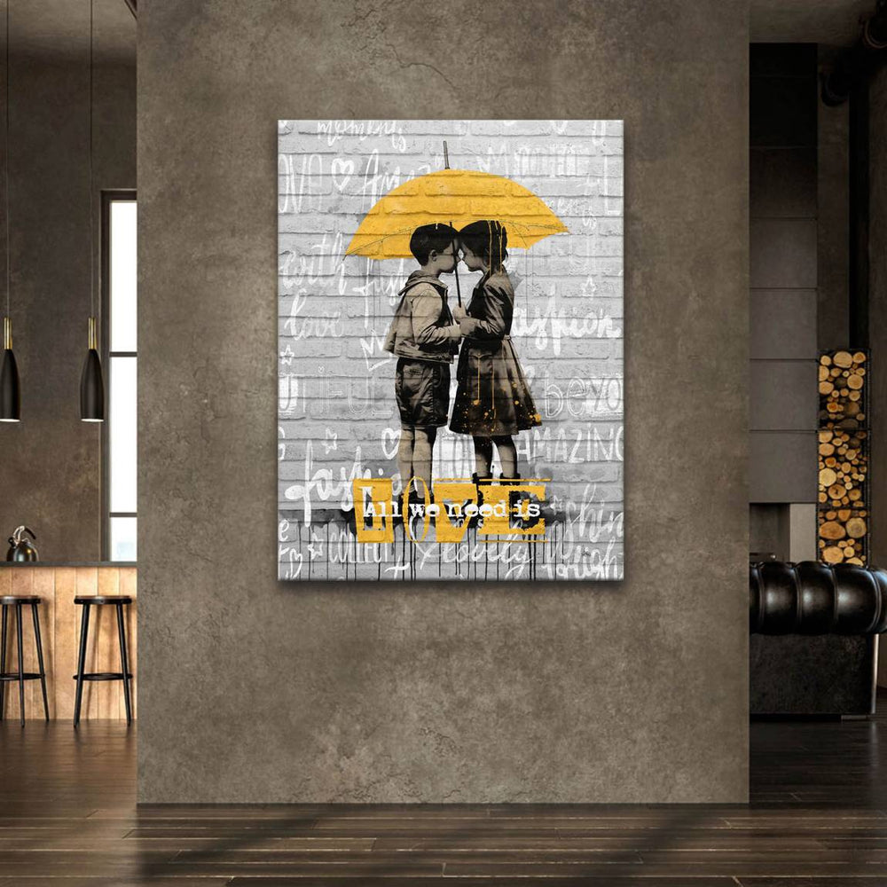 Monochrome kid figures with yellow accent and the words all we need is love in urban art