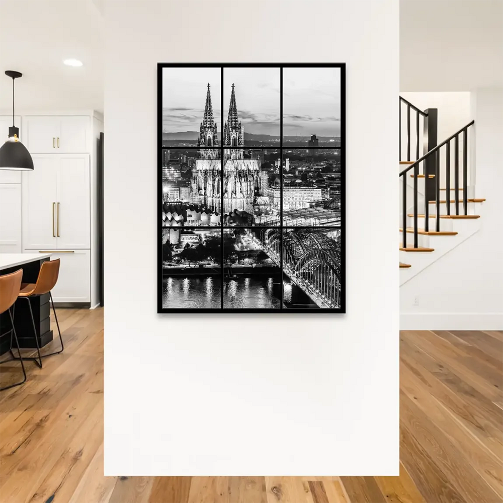 Wide black-and-white cityscape of Cologne’s skyline and riverfront at dusk