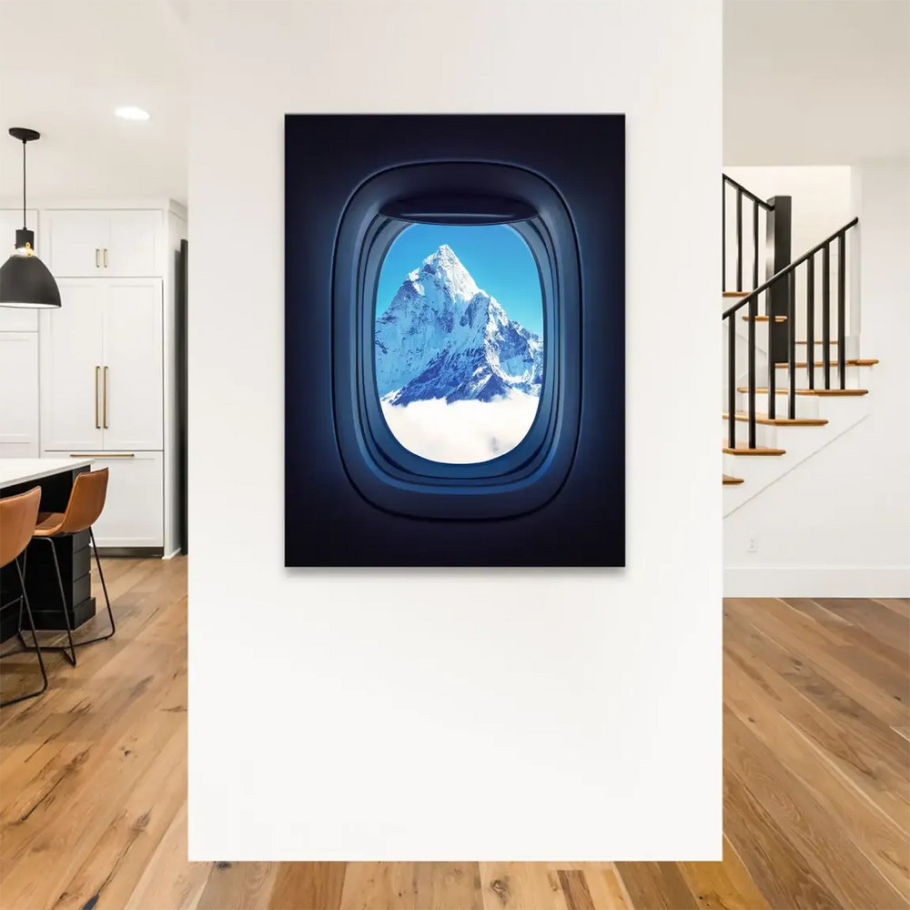 Aerial view of Everest from cabin window with clouds and blue sky