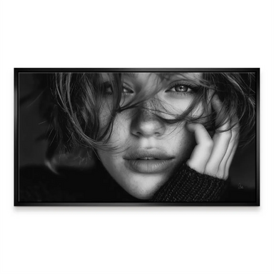 Pensive woman with delicate hand near the jawline in grayscale