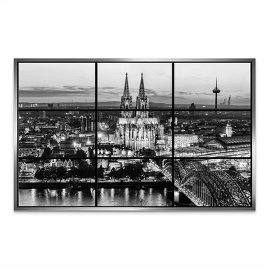 Cologne's nighttime skyline with landmark towers and shimmering reflections.
