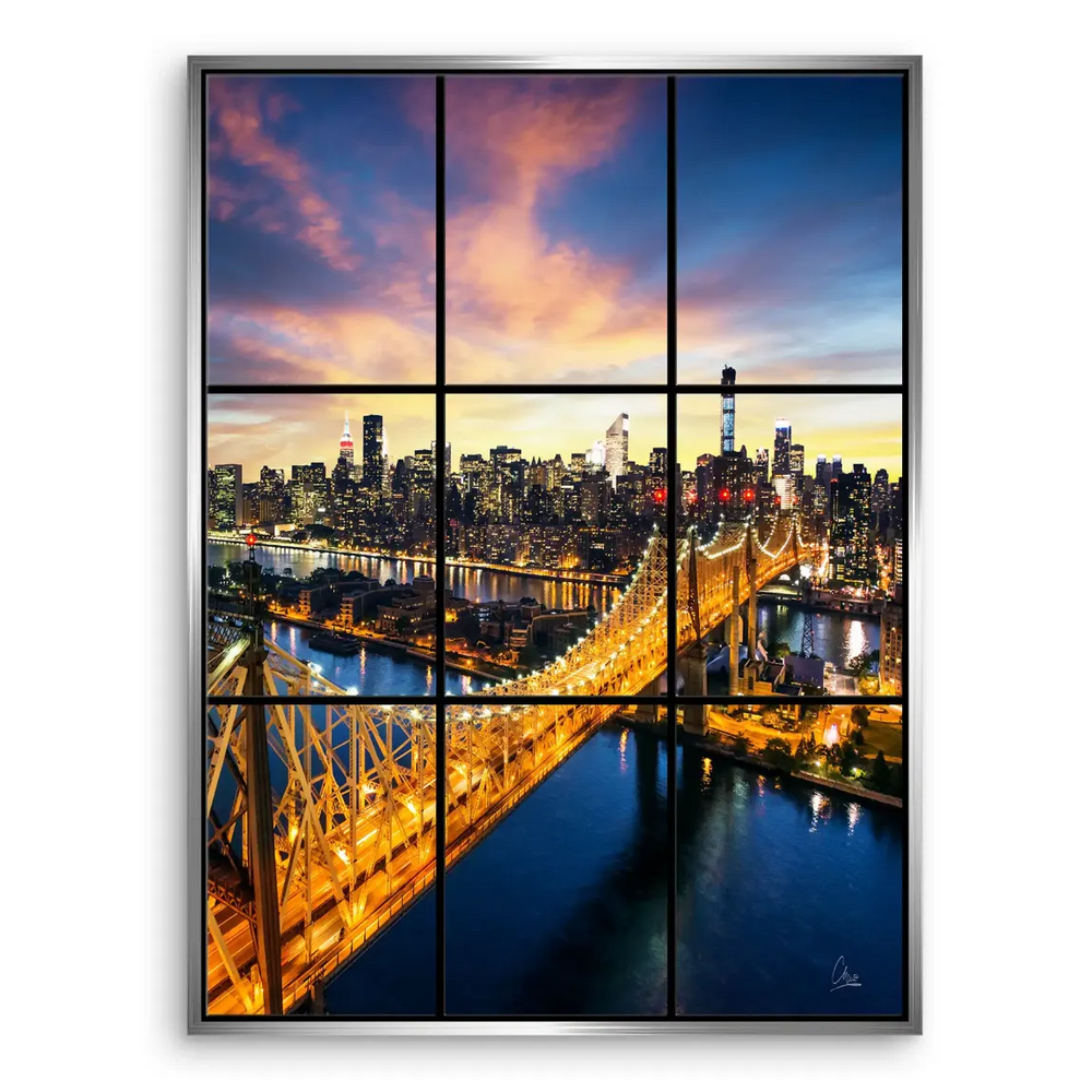Warm glow of city lights contrasting with a dark blue river under a dramatic sky.